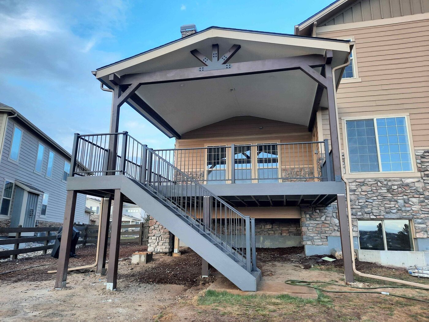 Covered deck with a gable roof and stone columns in Castle Rock